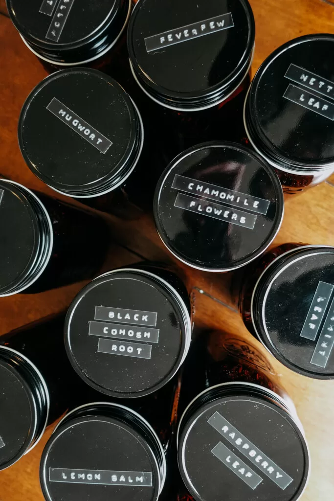 jar lids with black labels containing herbs