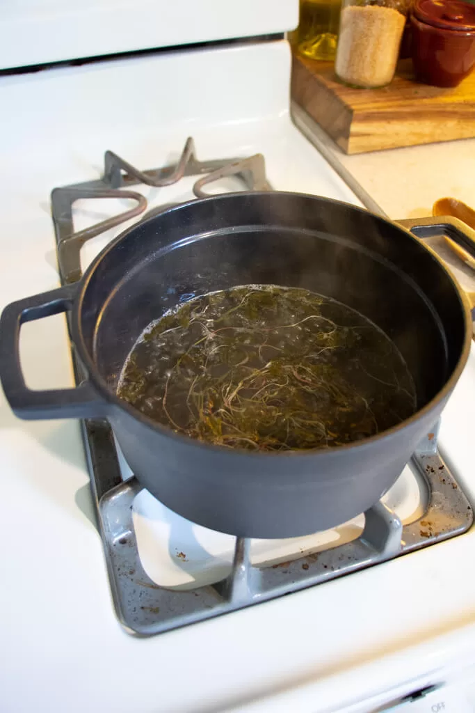 simmering sorrel simple syrup in black sauce pot