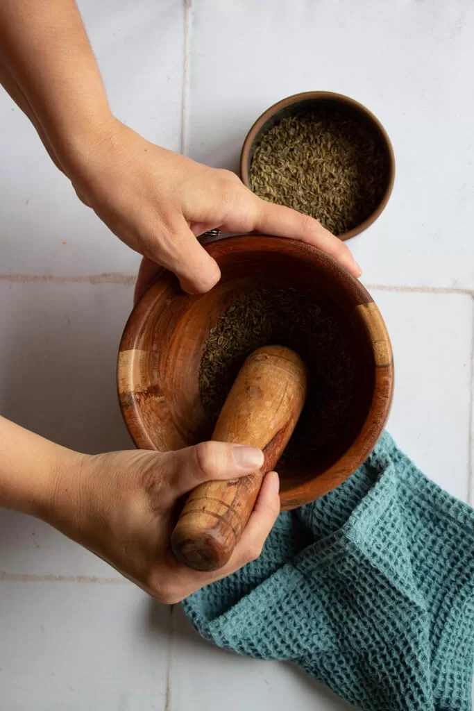 crushing dill seeds with mortar and pestle