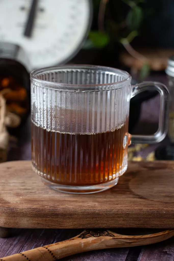 herbal tea for anxiety in clear mug on wood pedestal