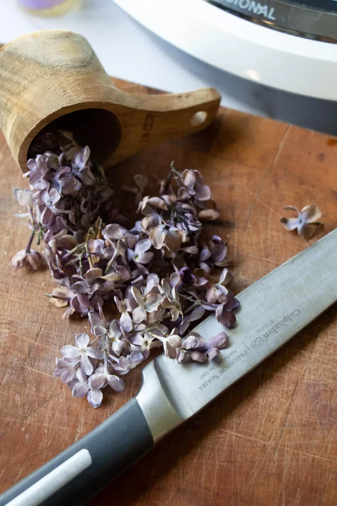 chopped lilacs with knife on wood cutting board