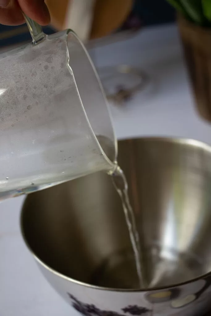 pouring hot water in bowl from glass measuring cup