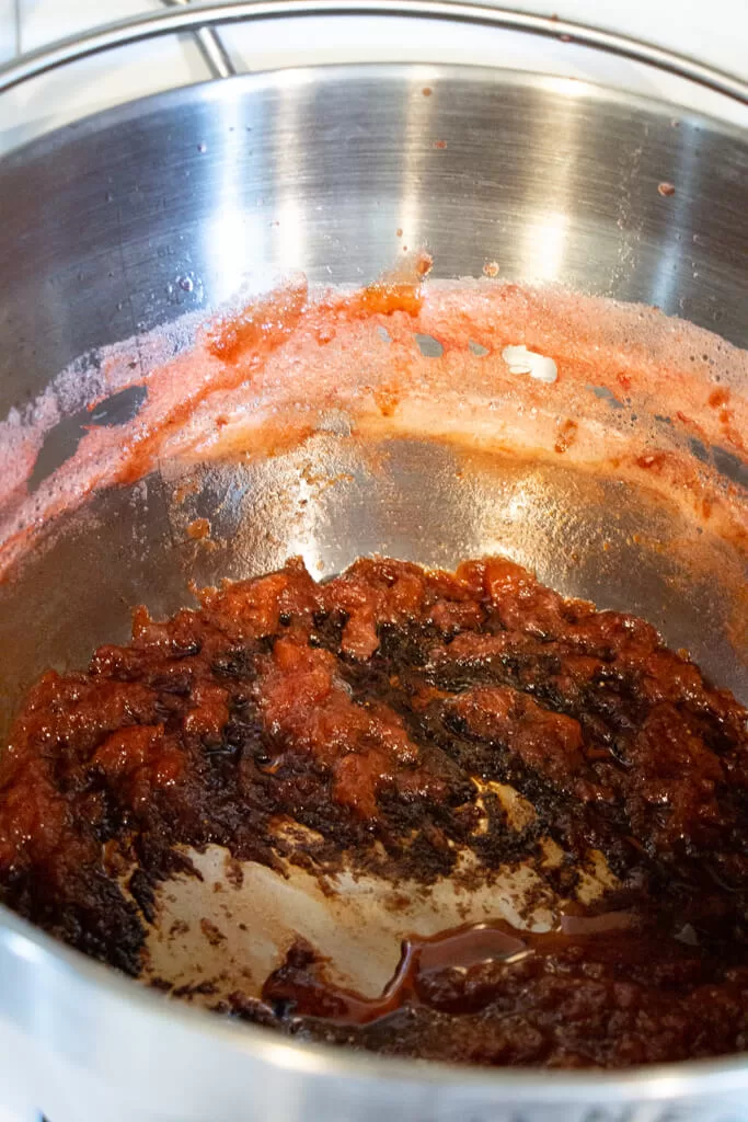 burnt jam and black crust stuck of the bottom of a jam pot