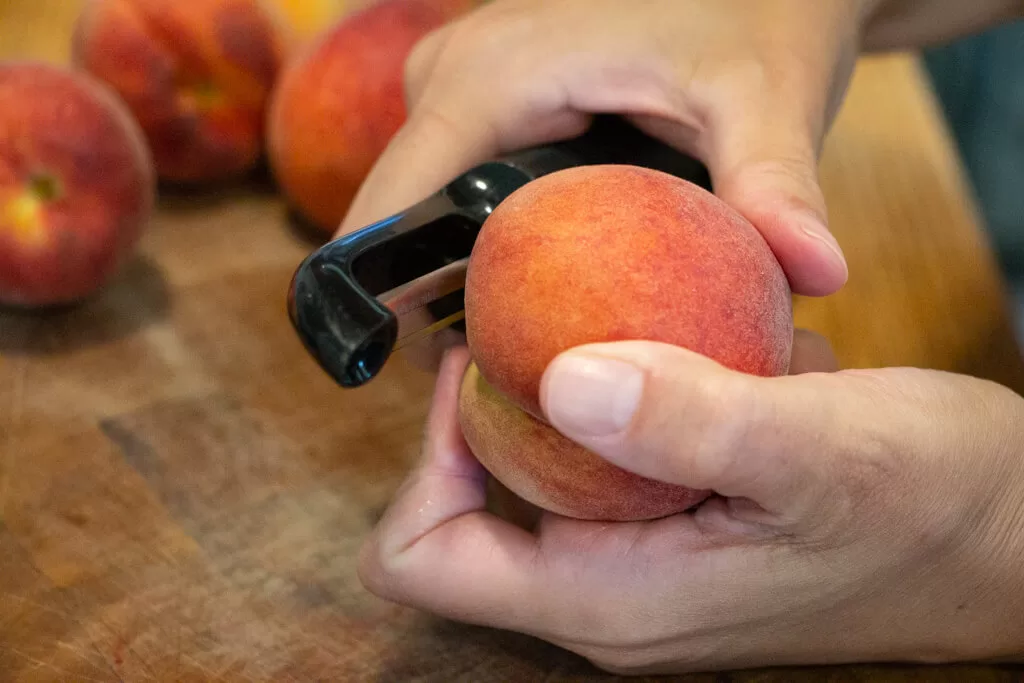 peeling peach with a peeler