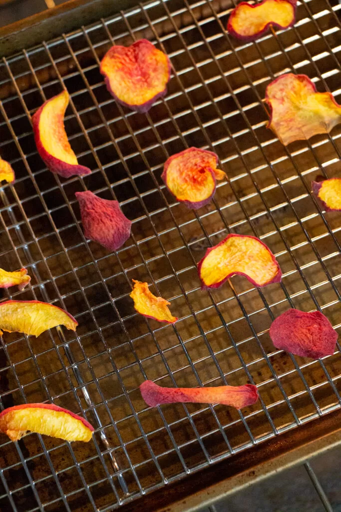 peach slices on baking rack with metal cooling rack insert- slightly dried