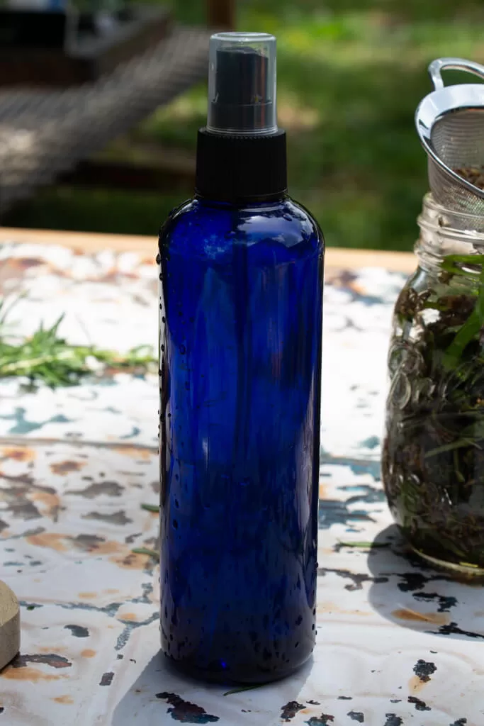 cobalt blue bottle of bug spray sitting on table with rusted tin top