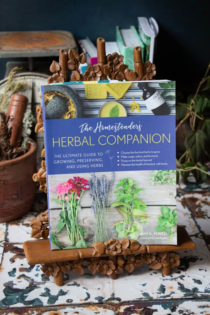 the homesteaders herbal companion- book with herbs on the front 
