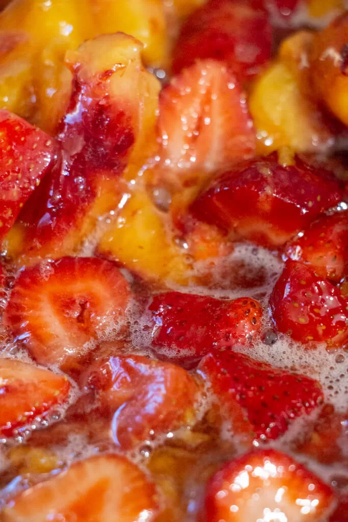 close up of simmering peaches and strawberries