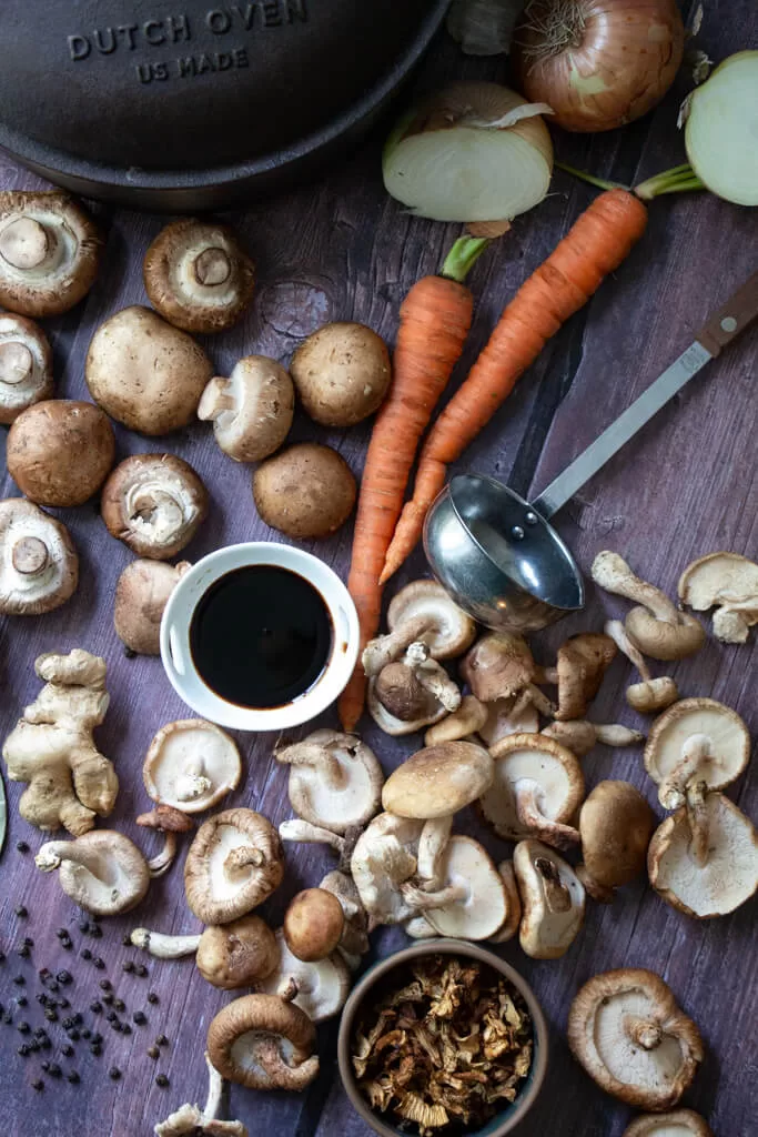 mushroom broth ingredients spread out on wood table