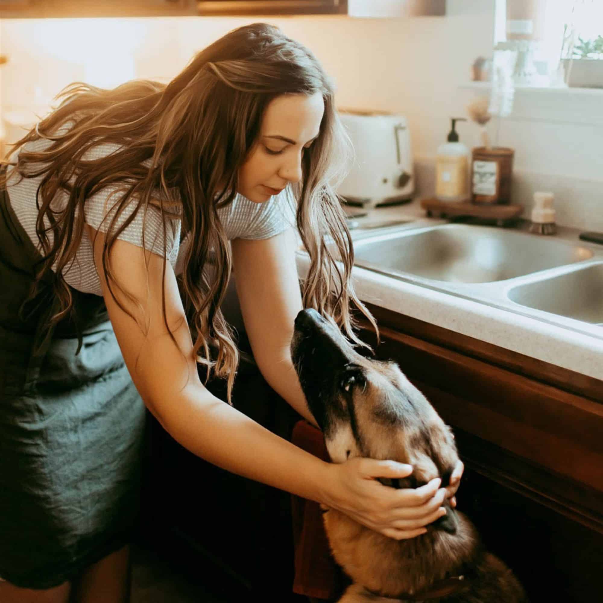 brittany in the kitchen petting her German Shepherd Dog