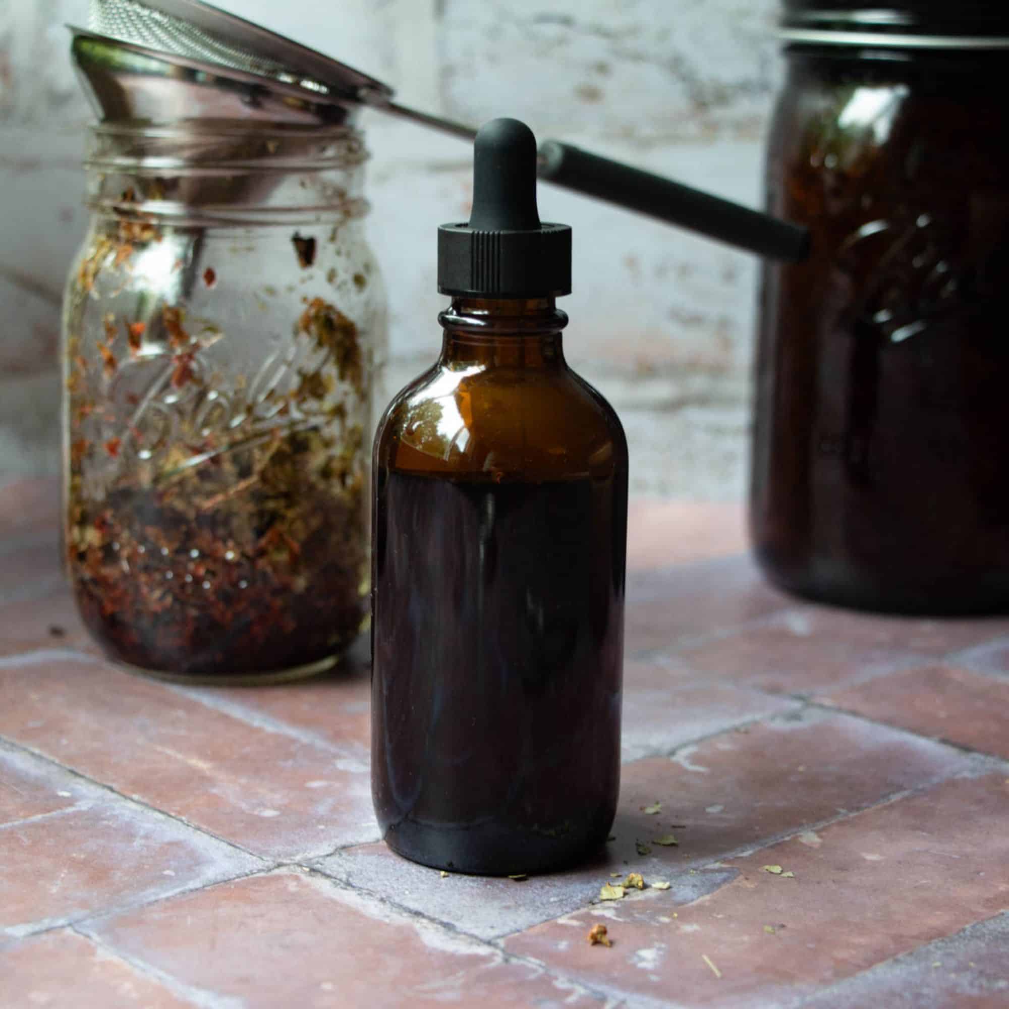 final heart tincture with spent herbs in mason jar in the background