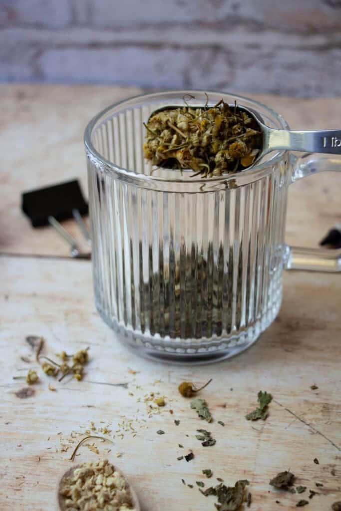 putting dried herbs in mug