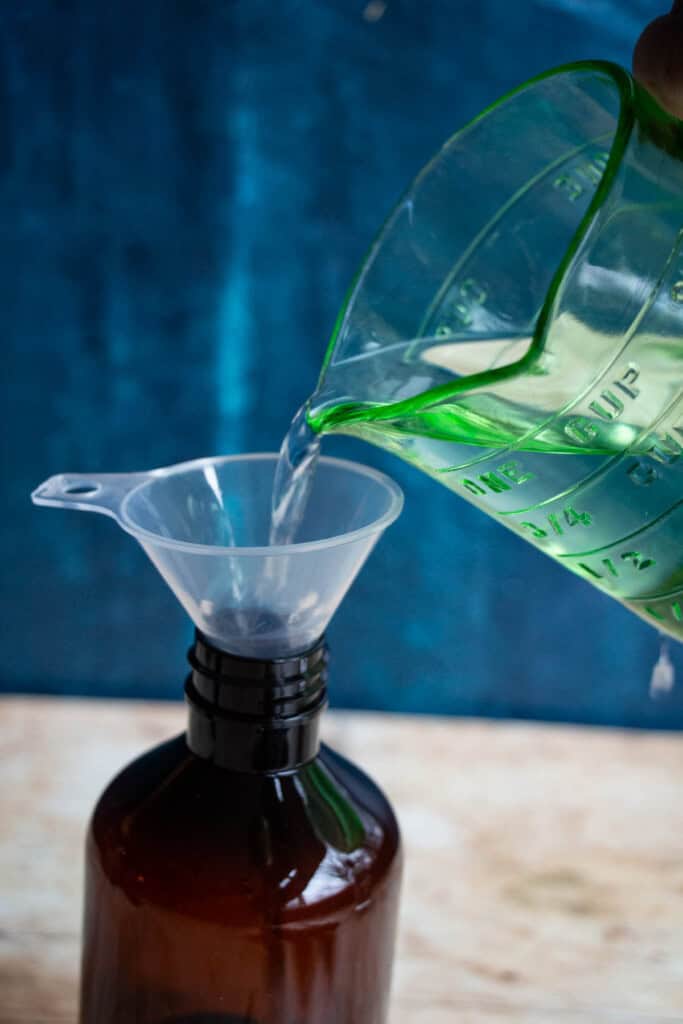 pouring alcohol into amber bottle