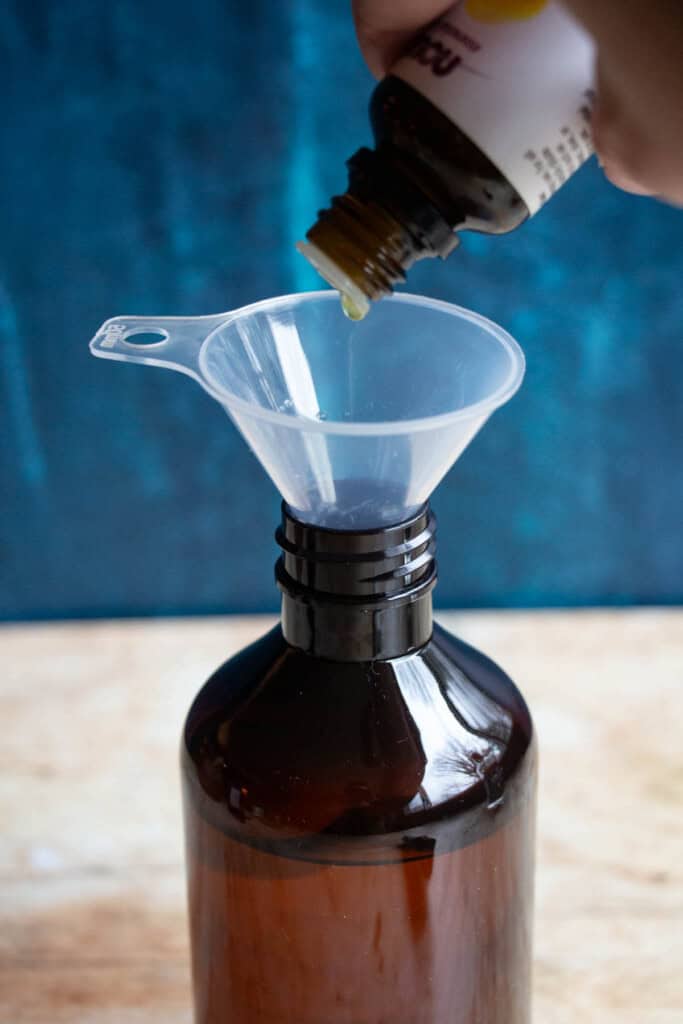 dropping essential oils into amber bottle