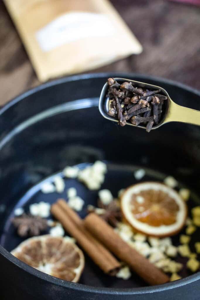 putting cloves and other ingredients into simmer pot